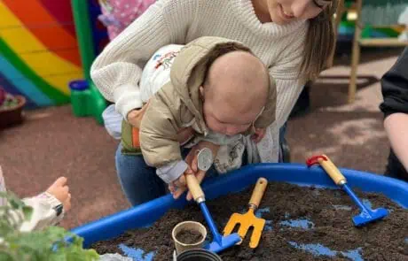 Babies planting seeds with staff