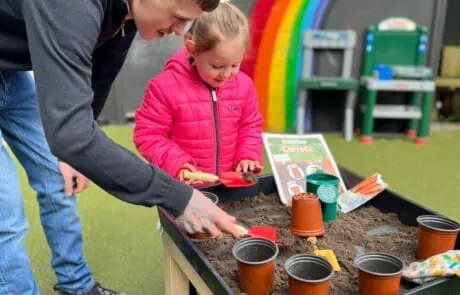 Nursery child and parent planting seeds