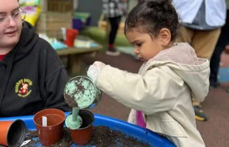 Nursery child watering seeds
