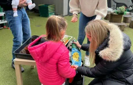 Nursery family putting soil in plant pots